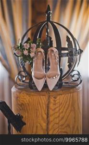 Shoes for the bride on a special stand.. Womens beige shoes on a stand with a bouquet 2368.