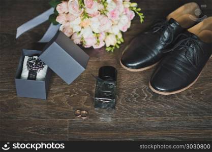 Shoes, rings and a bouquet with a clock on the table.. Mens holiday accessories on the table 664.. Mens holiday accessories on the table 664.