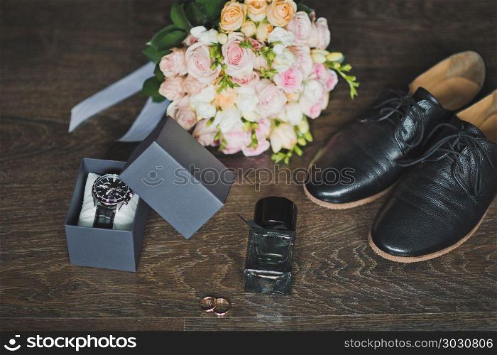 Shoes, rings and a bouquet with a clock on the table.. Mens holiday accessories on the table 665.. Mens holiday accessories on the table 665.