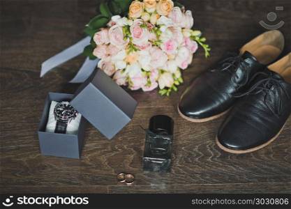 Shoes, rings and a bouquet with a clock on the table.. Mens holiday accessories on the table 665.. Mens holiday accessories on the table 665.