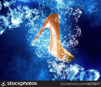 Shoes under water. Heeled shoe sinking in clear blue water