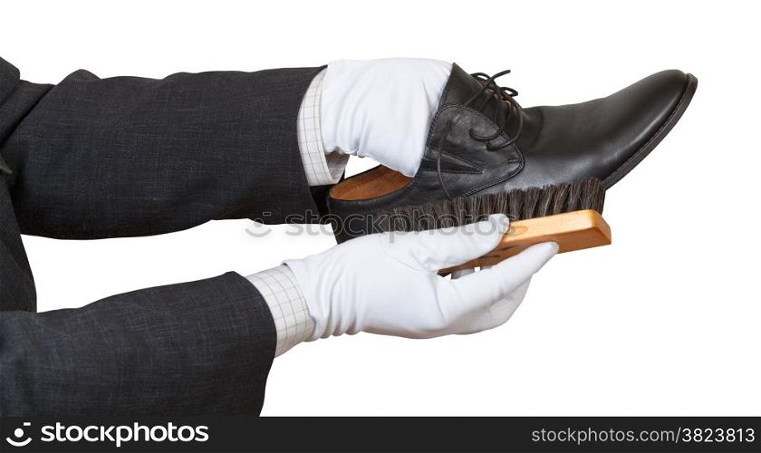Shoeshiner in white gloves brushing black shoe by brush isolated on white background