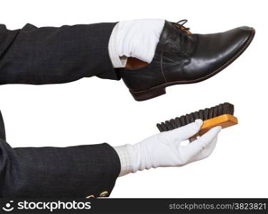 Shoeshiner in white gloves cleaning black shoes by brush isolated on white background