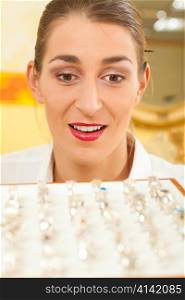 Shop assistant at the jeweler with jewelry