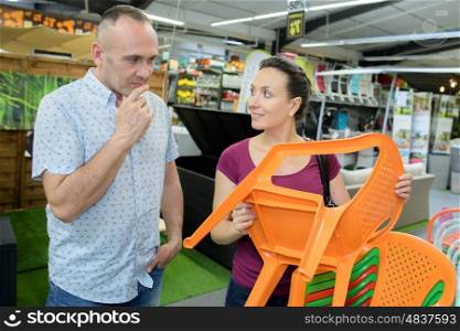 shop-assistant helping a customer to buy a chair