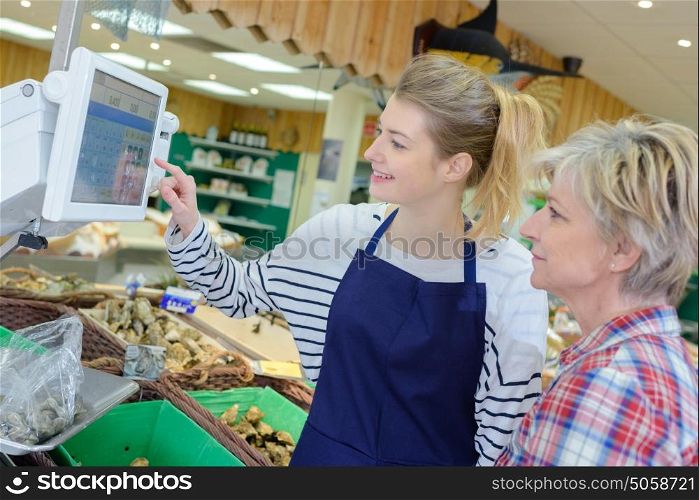 shop assistant weighing fruit