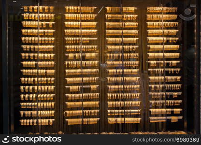 Shop display of dozens of golden bracelets and bangles