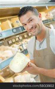 Shop worker holding expensive cheese