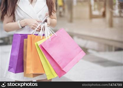 Shopaholic Women holding shopping bags ,money ,credit card person at shopping malls.Fashionable Woman love online website with sales tag on black Friday. E-commerce fashion digital marketing lifestyle