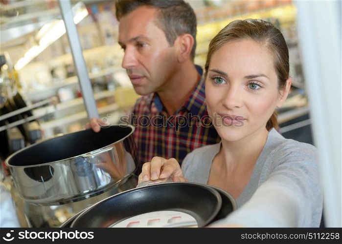 shoppers choosing pans in professional wholesale store