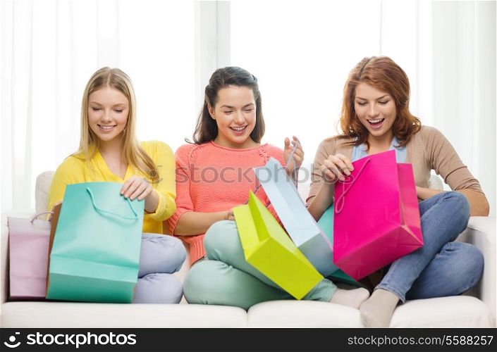 shopping and lifestyle concept - three smiling teenage girls with many shopping bags at home