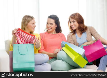 shopping and lifestyle concept - three smiling teenage girls with many shopping bags at home