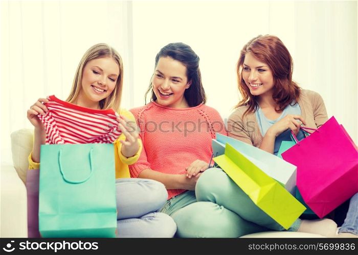 shopping and lifestyle concept - three smiling teenage girls with many shopping bags at home