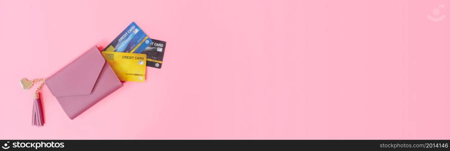 shopping and payment concept from pink wallet with credit cards or discount card on pink background. web banner size.