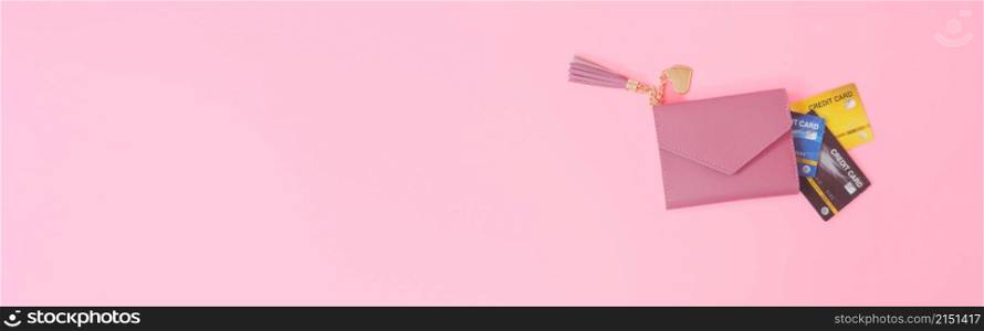 shopping and payment concept from pink wallet with credit cards or discount card on pink background. web banner size.