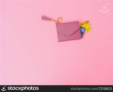 shopping and payment concept from pink wallet with credit cards or discount card on pink background.