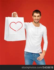 shopping and relationships concept - handsome man with shopping bags and heart on it
