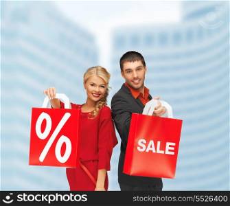 shopping and sale concept - man and woman with shopping bag outdoors