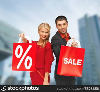 shopping and sale concept - man and woman with shopping bag outdoors