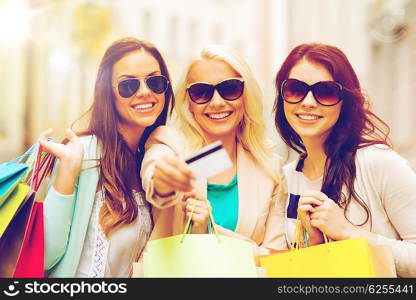 shopping and tourism concept - beautiful girls with shopping bags and credit card in ctiy. girls with shopping bags in ctiy