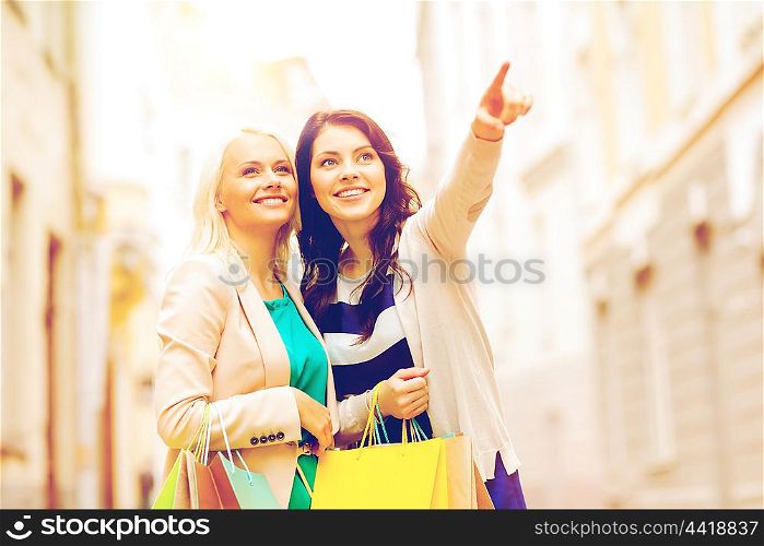 shopping and tourism concept - beautiful girls with shopping bags in ctiy. girls with shopping bags in ctiy