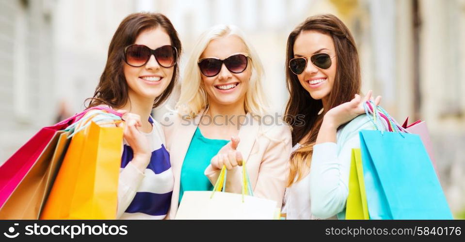 shopping and tourism concept - beautiful girls with shopping bags in ctiy. girls with shopping bags in ctiy