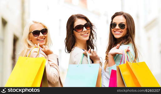 shopping and tourism concept - beautiful girls with shopping bags in ctiy. girls with shopping bags in ctiy