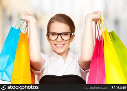 shopping and tourism concept - beautiful woman with shopping bags in ctiy