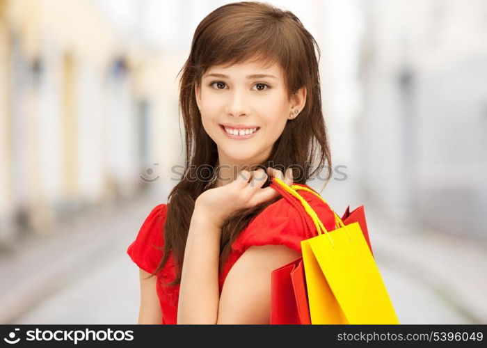 shopping and tourism concept - beautiful woman with shopping bags in ctiy