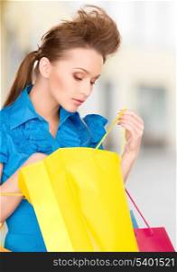 shopping and tourism concept - beautiful woman with shopping bags in ctiy