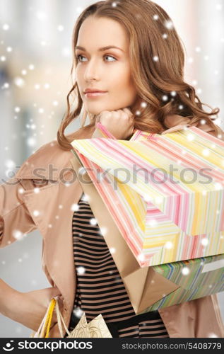 shopping and tourism concept - beautiful woman with shopping bags in ctiy