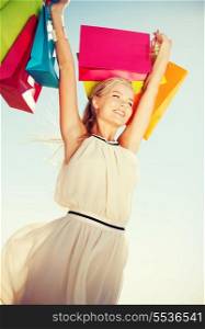 shopping and tourism concept - woman with shopping bags