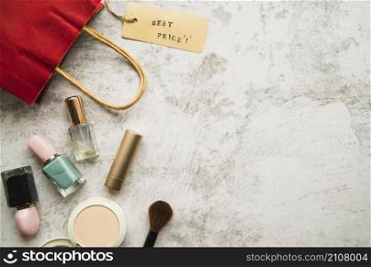 shopping bag with little tag near lipstick nail polish