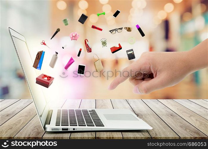 Shopping cart and laptop computer with products on wood bokeh background, shop online concept.