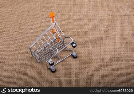 Shopping cart on canvas background. Shopping cart placed on canvas background