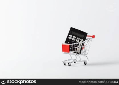 Shopping cart trolley and calculator on white background with copy space. Concept for grocery expenses and consumerism