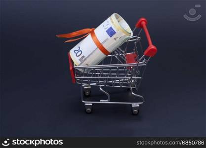 shopping cart with euro banknotes on black