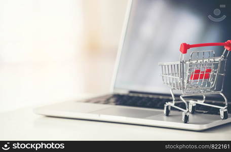 shopping cart with laptop on the desk, online shopping concept