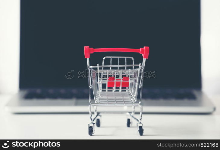 shopping cart with laptop on the desk, online shopping concept