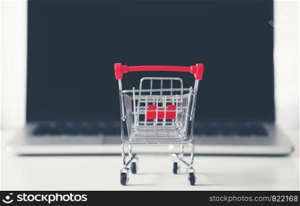 shopping cart with laptop on the desk, online shopping concept