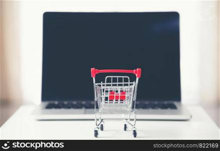 shopping cart with laptop on the desk, online shopping concept
