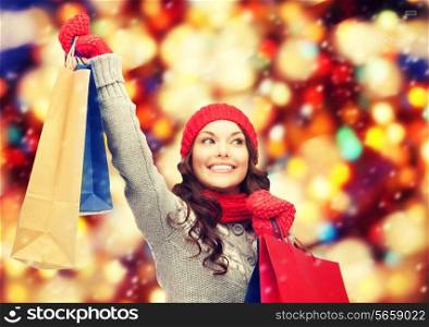 shopping, christmas sale and gifts concept - happy asian woman in winter clothes with shopping bags