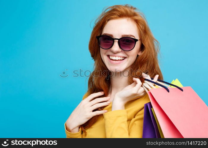 Shopping Concept - Close up Portrait young beautiful attractive redhair girl smiling looking at camera. Blue Pastel Background. Copy space.