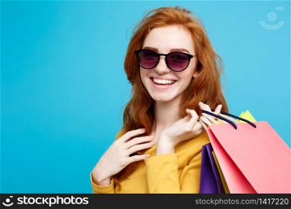 Shopping Concept - Close up Portrait young beautiful attractive redhair girl smiling looking at camera. Blue Pastel Background. Copy space.