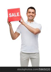 shopping, consumerism, discount and people concept - smiling man with red sale sigh