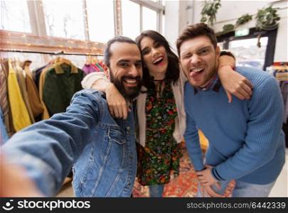 shopping, fashion and people concept - happy smiling friends taking selfie at vintage clothing store. friends taking selfie at vintage clothing store
