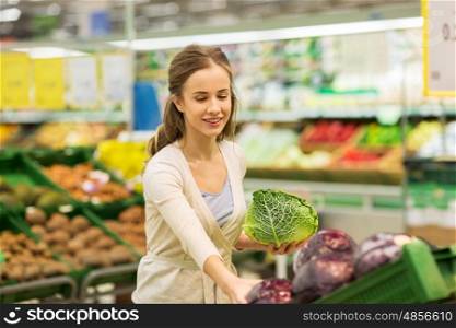 shopping, food, sale, consumerism and people concept - happy woman buying savoy at grocery store or supermarket