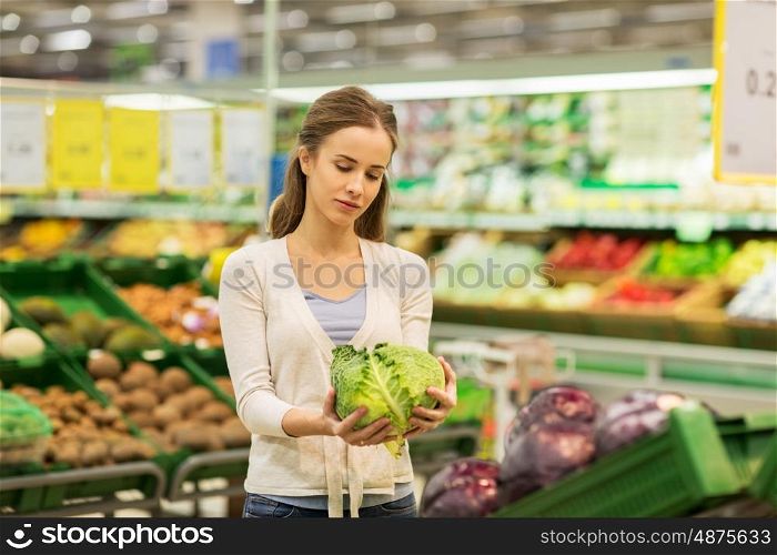 shopping, food, sale, consumerism and people concept - happy woman buying savoy at grocery store or supermarket
