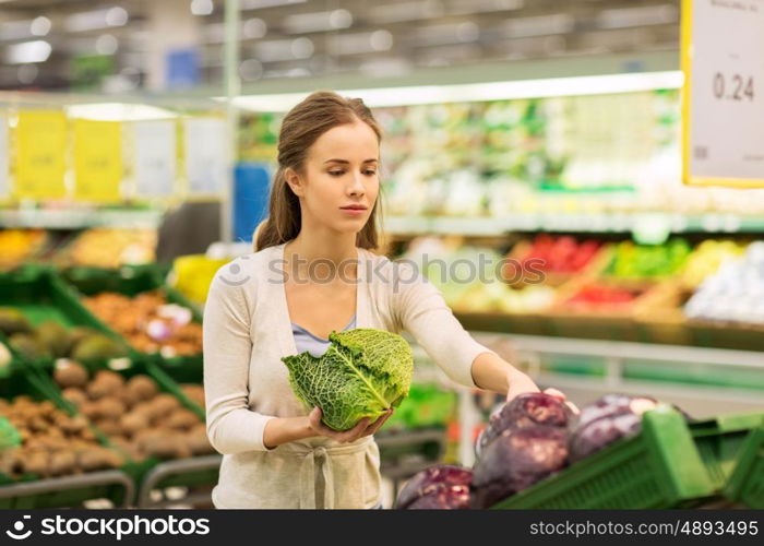 shopping, food, sale, consumerism and people concept - happy woman buying savoy at grocery store or supermarket