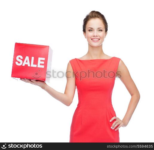 shopping, gifts, christmas and holiday concept - smiling young woman in dress with red sale sign